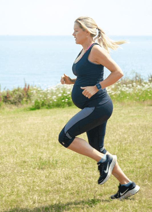 Pregnant woman running outdoors in FittaMamma Ultimate High Impact Maternity Sportswear Top, showcasing activewear support during pregnancy.