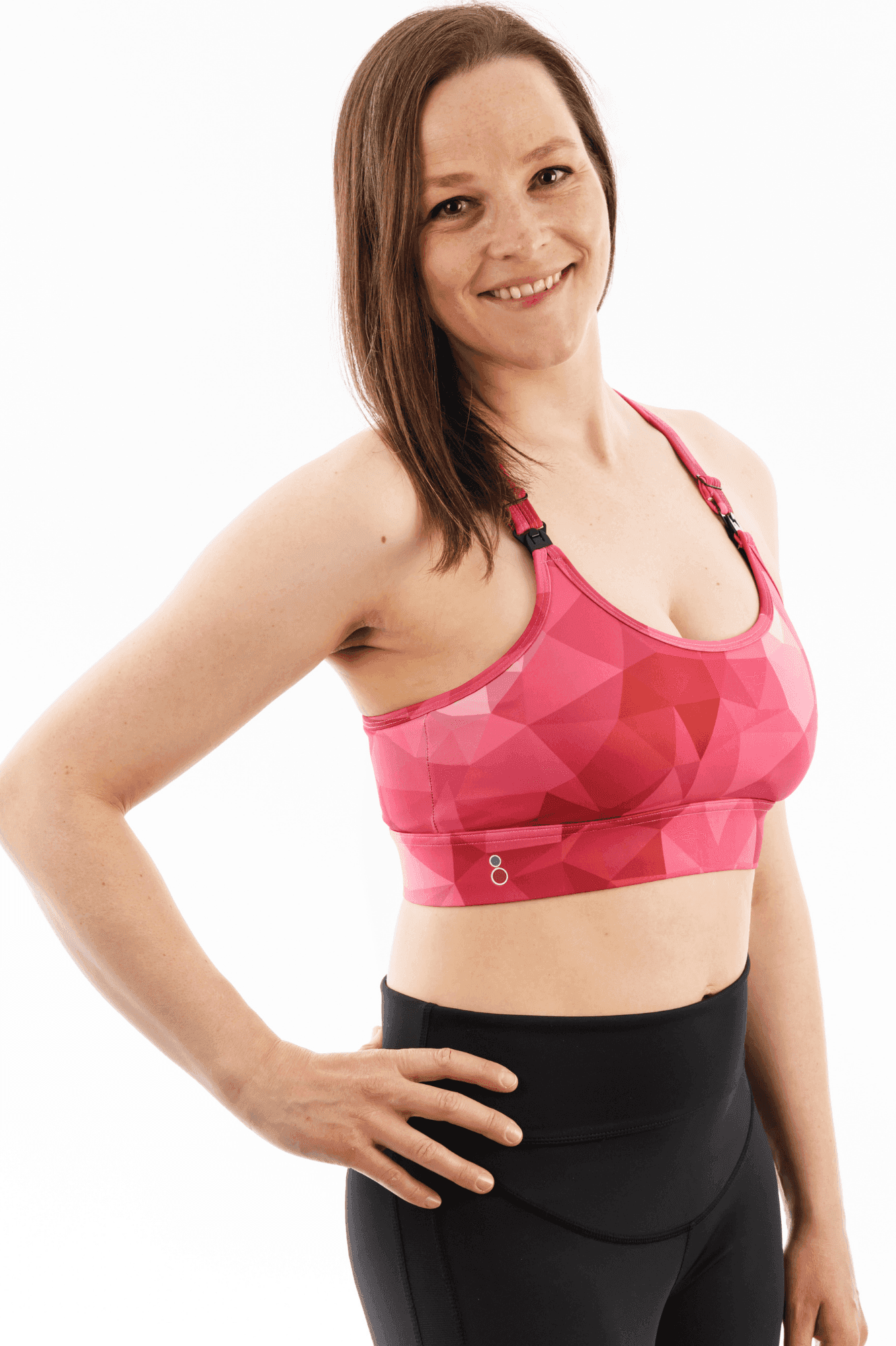 Front view of woman in pink maternity and feeding sports bra with geometric print, designed for high impact support and nursing ease.
