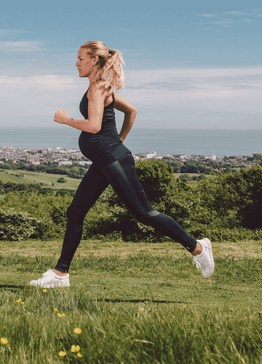 Pregnant woman running outdoors in Ultimate Maternity Workout Leggings by FittaMamma, designed for superior support and flexibility.
